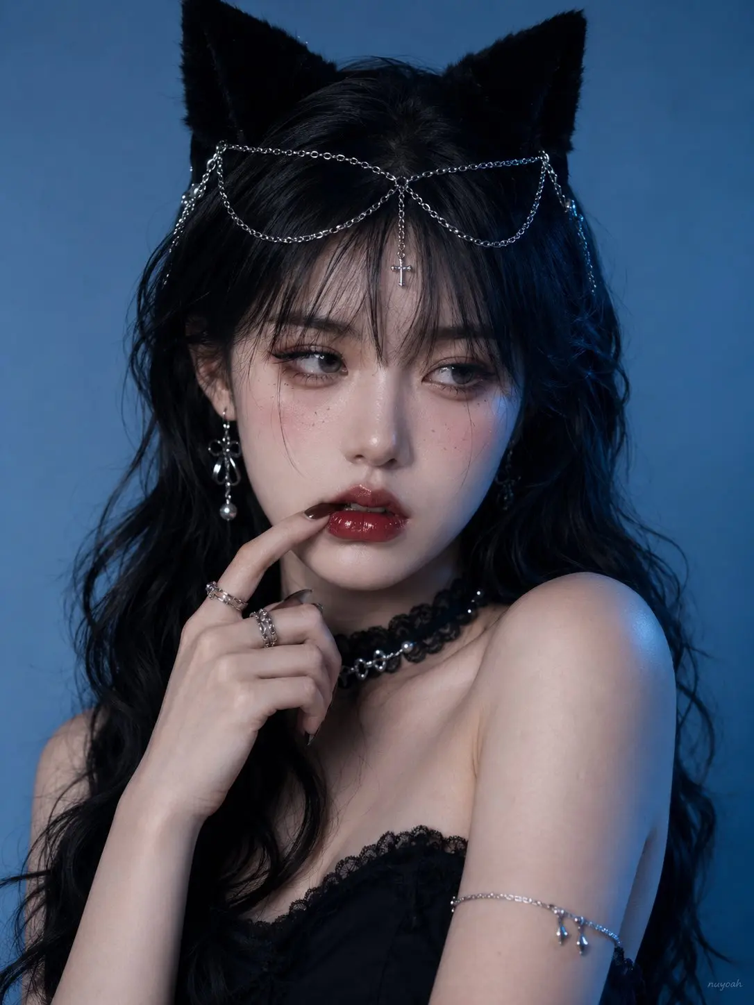 trend prompt: ： 真人摄影，真实人物，社媒美妆写真与暗黑甜酷猫系造型，竖幅 3:4 半身近景，平视略近镜头，人物占画面约 75%，头部靠上居中，极简冷蓝渐变背景留白。成年女性，冷白到象牙白肤调，脸颊淡粉腮红与细小雀斑妆，右侧皮肤受蓝青环境光轻微偏色；黑色长卷发，中分碎刘海，黑色绒面猫耳发饰，银色链条从猫耳垂坠到额前，中央小十字吊坠。身体微侧向右，肩颈轻微前收，单侧肩臂露出；左手从画面左下方抬起，食指指甲与指腹斜向压住下唇偏画面左侧，保留下唇局部压陷、唇线中断、嘴缝轻微收窄和唇面高光断点，不要变成手指悬停或普通轻触。眼睛自然睁开但神情放松，虹膜上缘被上眼睑正常轻覆，瞳孔整体斜向画面右侧（人物自身左侧），不直视镜头；嘴唇微张，深红水润唇妆。黑色蕾丝颈圈贴合颈部并带珍珠反光，银色耳环、戒指和上臂细链冷亮。正面偏左柔光提亮脸部，右侧冷蓝边缘光，黑发黑饰品与蓝背景占主导，深红唇色少量点缀；中高清手机 / CCD 写真质感，轻微磨皮、柔焦美颜、背景低噪点，发丝与银链局部锐利。避免动漫插画感、避免普通清新头像、避免过度干净棚拍、避免直视镜头、避免丢失唇部受力形变。